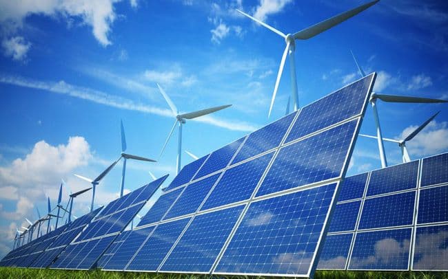 Solar panels and wind turbines under a bright blue sky, symbolizing renewable energy.